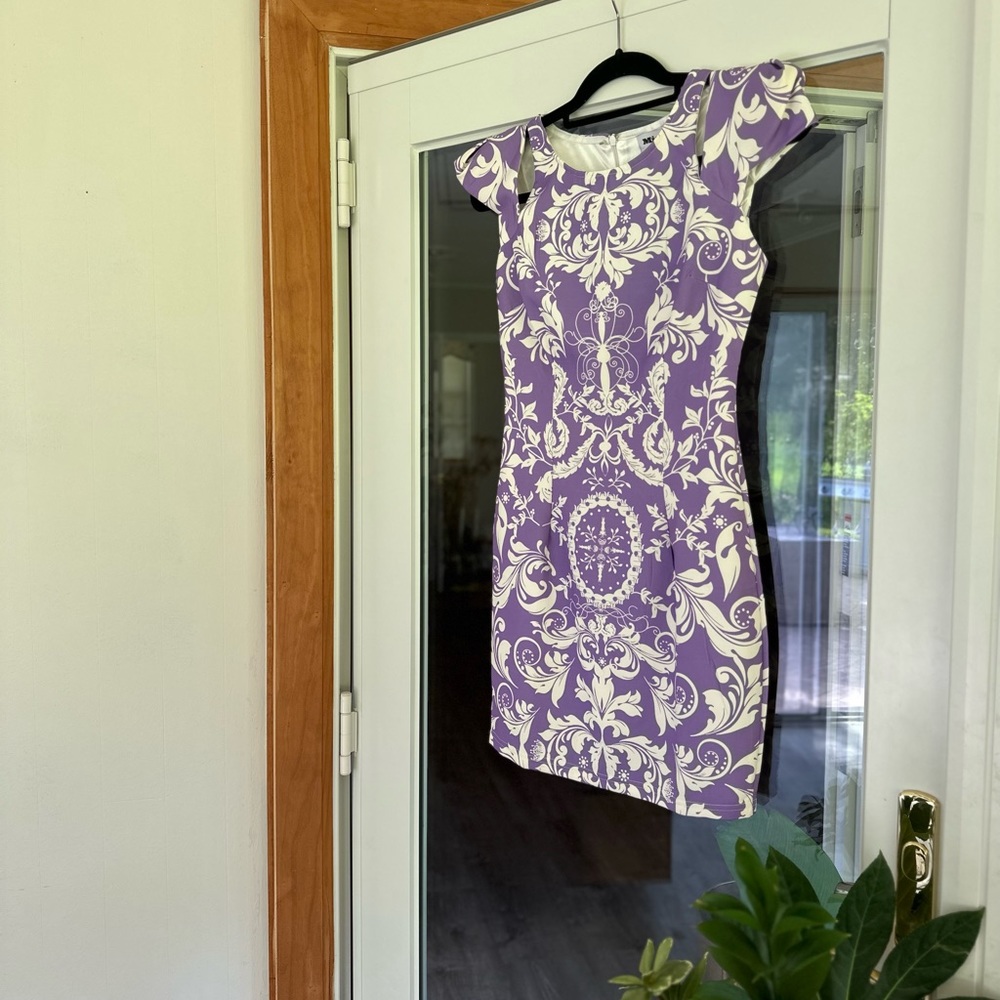 Purple, printed mini dress with shoulder slit accents.